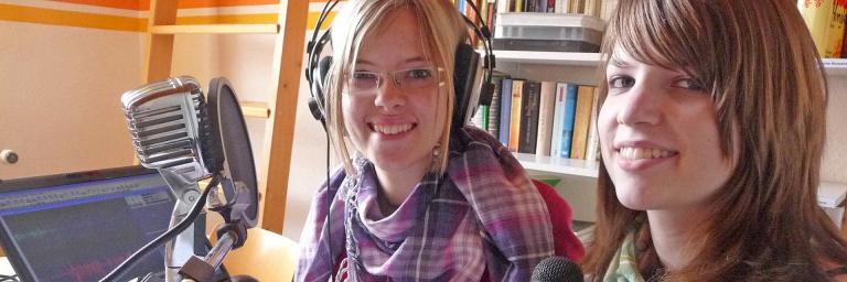 Zwei Jugendliche vor einem Mikrofon